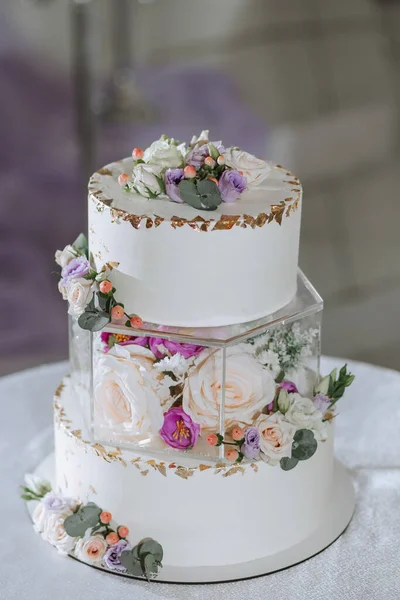 A delicious wedding. three-tiered cake decorated with flowers. Candy bar for a banquet. Celebration concept. Fashionable desserts. Table with sweets, candies. Fruits