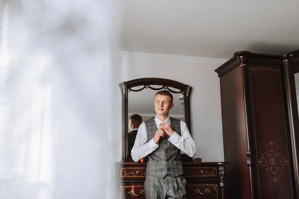 一个时髦的年轻人正在穿西装打领带 商业风格 时尚的形象 新郎正在准备婚礼 性感男人站在那里 把目光移开 — 图库照片