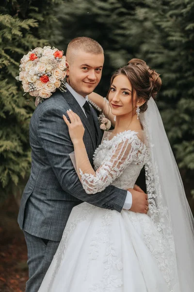 Eleganti Sposi Abbracciano Teneramente Baciano Bella Sposa Con Bouquet Moderno — Foto Stock