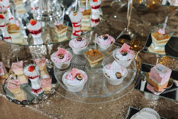 A sweet table at a wedding. Table with cakes and sweets at the festival. Birthday sweets
