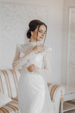 Arap tarzı dantelli ve kristalli lüks gelinlik içinde güzel bir gelinin moda portresi. Gelinlik giyen, düğün makyajlı ve saç stili olan esmer mutlu kadın..