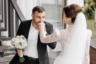 Damat geline nazikçe dokunur, gelin ve damada yürür. Güzel gelin. Yeni yaratılmış düğün ailesi. Damat gelinin elini öpüyor. Aşık güzel bir çift.