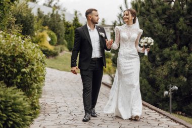 Düğün günlerinde harika bir yerde güzel gelinlerin yürüyüşü. Modern bir evin arka planına karşı..