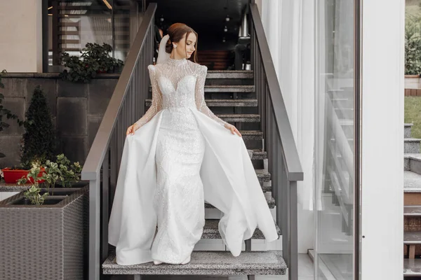 一个穿着时髦婚纱的全长新娘站在餐馆台阶上向前走着 炫耀她的婚纱 婚礼当天 最好的事 — 图库照片
