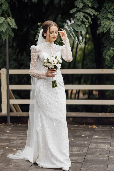 구슬로 드레스의 신부는 장미와 녹지의 결혼식 꽃다발을 보유하고 있습니다 세련된 — 스톡 사진