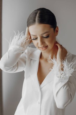 Sabahları beyaz pijamalı genç ve güzel bir gelin. Gelinin oteldeki sabahı. Uzun, modaya uygun bir peçe. Modern saç ve makyaj.