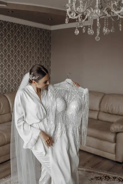 Невеста Держит Свое Изящное Свадебное Платье Позирует Своей Комнате Утро — стоковое фото