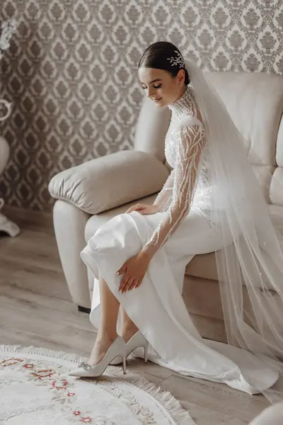 Bride Wedding Dress Puts Shoes Her Feet While Sitting Sofa — Stock Photo, Image