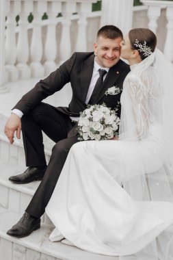 Gelin ve damat Roma tarzı sütunların yanında kucaklaşıyor. Nefis bir düğün.