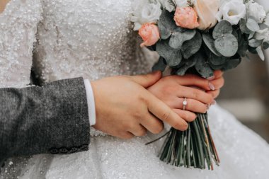 Portre. Gelin ve damat ellerinde buketle poz veriyorlar. Buketi vurguluyorum. Ormanda bir yürüyüş. Kış düğünü