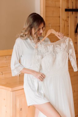 Gelinin otel odasında geçirdiği sabah. Gelin düğün töreni için hazırlanıyor. Kız elbise giyer..