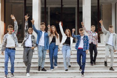 Arkadaşlık, hareket, eylem, özgürlük ve insanların kavramları - bir grup mutlu genç öğrenci veya okul arkadaşları poz veriyor ve dışarıda güzel bir yerde eğleniyorlar..