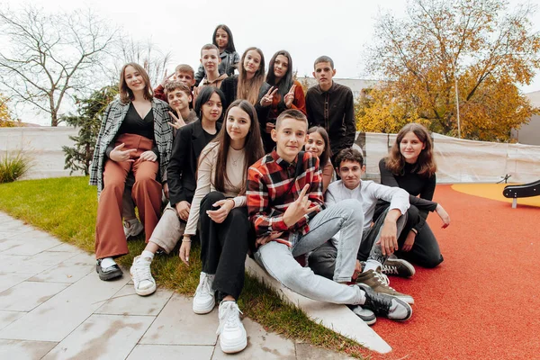 friendship, movement, action, freedom and people concept - group of happy teenagers or school friends posing and having fun outdoors on background of beautiful place or college.