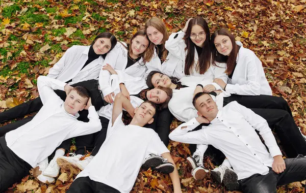 friendship, movement, action, freedom and people concept - group of happy teenagers or school friends posing and having fun outdoors against nature or forest background.