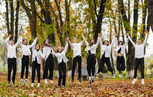 friendship, movement, action, freedom and people concept - group of happy teenagers or school friends posing and having fun outdoors against nature or forest background.