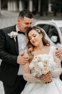 Aşık düğün çifti. Güzel bir gelin ve zarif bir damat nazikçe sarılıp günün tadını çıkarın. Yeni evliler için şık bir çift. Evlilik kavramı