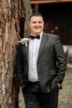 Siyah takım elbiseli yakışıklı ve erkeksi bir damat portresi. Kış mevsiminde doğada damat.