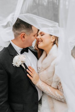 Aşık düğün çifti. Güzel bir gelin ve zarif bir damat nazikçe sarılıp günün tadını çıkarın. Yeni evliler için şık bir çift. Evlilik kavramı