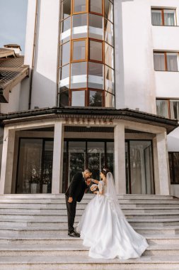 Aşık düğün çifti. Güzel bir gelin ve zarif bir damat nazikçe sarılıp günün tadını çıkarın. Yeni evliler için şık bir çift. Evlilik kavramı