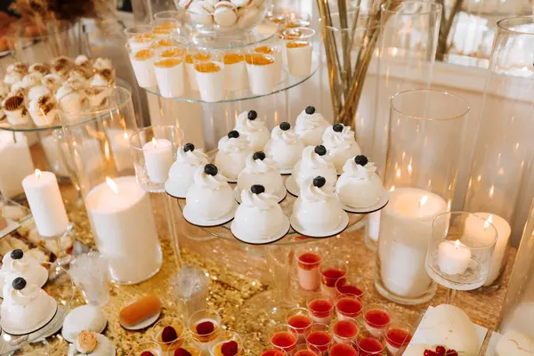 Candy bar for a wedding. Candy bar standing festive table with desserts, cupcakes and macarons. Beautiful and tasty.