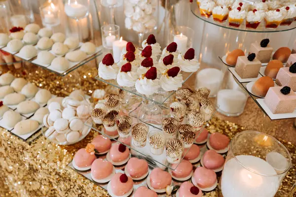 Candy bar for a wedding. Candy bar standing festive table with desserts, cupcakes and macarons. Beautiful and tasty.