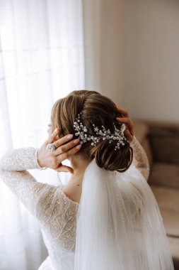 Lüks. İnci boncuklu zengin şık esmer. Zarif bir tarz. Saç tokasıyla sabitlenmiş bir saç teli olarak yapılmış kadın saç modelinin yakından çekimi..