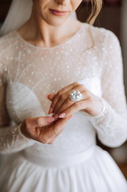 Modern bir manikür ve güneş ışığıyla bir kadının parmağına takılmış zarif bir elmas yüzüğün yakın çekimi. Aşk ve düğün kavramı. Yumuşak ve seçici odak.