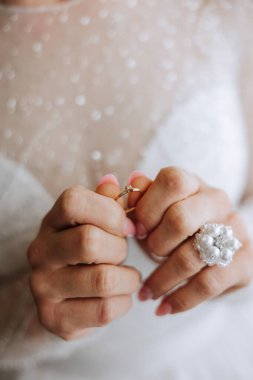 Modern bir manikür ve güneş ışığıyla bir kadının parmağına takılmış zarif bir elmas yüzüğün yakın çekimi. Aşk ve düğün kavramı. Yumuşak ve seçici odak.