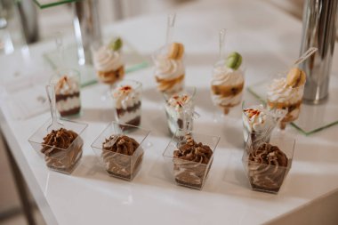 Düğün ziyafeti için bademli kurabiyeler ve çeşitli tatlı pastalar. Lezzetli bir karşılama, lüks bir tören. Tatlı ve tatlılı bir masa. Lezzetli Fransız tatlıları tabakta ya da masada.