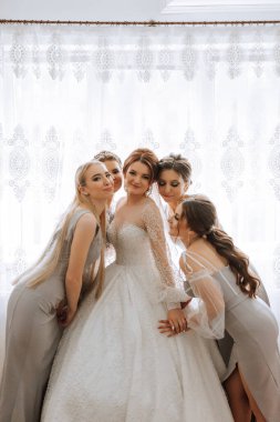 Arkadaşlar sabah gelinle sevinirler. Fotoğraf çekerler, gülümserler, gelinin elbisesini bağlamasına yardım ederler..