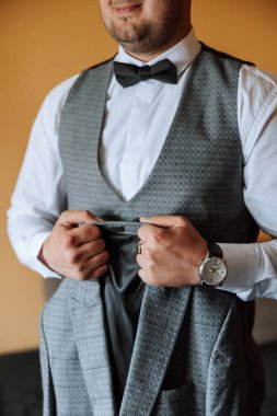 Lüks bir iş adamı. Erkek tarzı. Eller yukarı, giyinmek, erkek tarzı, şık bir adam. Genç bir iş adamının moda portresi, sıradan bir kumaş elbise giymiş yakışıklı bir erkek model..