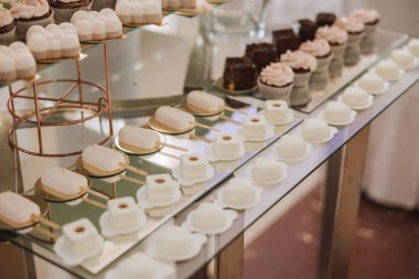 Düğün ziyafeti için bademli kurabiyeler ve çeşitli tatlı pastalar. Lezzetli bir karşılama, lüks bir tören. Tatlı ve tatlılı bir masa. Lezzetli Fransız tatlıları tabakta ya da masada.