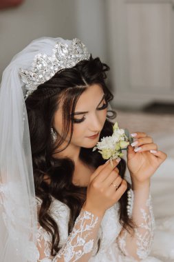 Genç bir gelinin harika bir portresi. Uzun kıvırcık saçlı, düğün makyajı ve mücevher çelengi olan güzel bir gelin. İçi güzel kahverengi gözlü bir düğün fotoğrafı modeli..