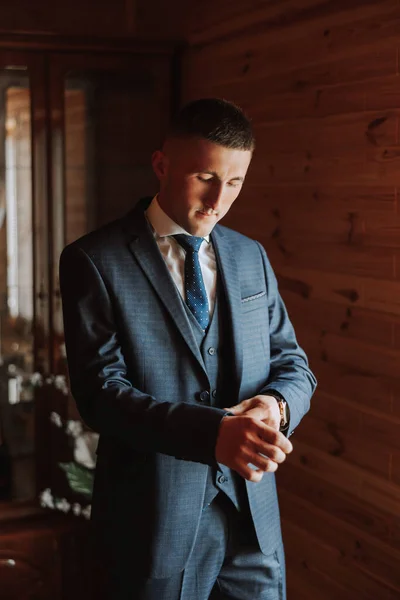 groom preparing for the wedding ceremony in the morning. Groom\'s morning. Preparation for the groom\'s morning. The groom puts on a jacket. The confident look of a mature man.