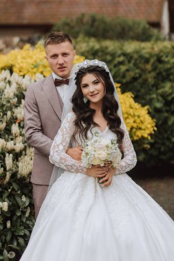 Düğün için. Aşk ve çift düğün için bahçede. Törenin ve bağlılığın kutlanması. Tarihi kaydet. Güven. Gelin ve damat kucaklaşır. Gülümse ve sev. Mutlu ve aşık gelinlerin ve damatların fotoğrafı..