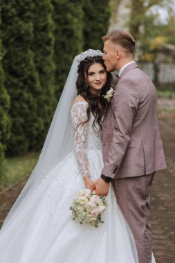 Düğün için. Aşk ve çift düğün için bahçede. Törenin ve bağlılığın kutlanması. Tarihi kaydet. Güven. Gelin ve damat kucaklaşır. Gülümse ve sev. Mutlu ve aşık gelinlerin ve damatların fotoğrafı..