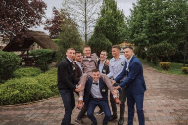 Damadın, damadın yanındaki neşeli, genç ve enerjik tanıklar. Arkadaşlar damadı tebrik eder. Damat ve komik arkadaşları yeni evlilerin düğün gününde eğleniyorlar..