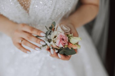 Çiçek yaka çiçekleri gelinin elinde. Düğün detayları. Gelin ve damadın ilk buluşması. Gelin damadı bekliyor..