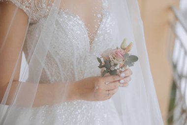 Çiçek yaka çiçekleri gelinin elinde. Düğün detayları. Gelin ve damadın ilk buluşması. Gelin damadı bekliyor..