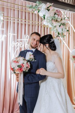 Düğün için. Aşk ve çift düğün için bahçede. Törenin ve bağlılığın kutlanması. Tarihi kaydet. Güven. Gelin ve damat kucaklaşır. Gülümse ve sev. Gelin damadı omuzlarından tutar..