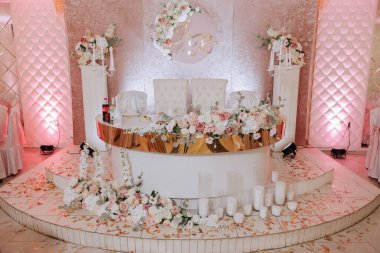 Bir restoranda tatil için romantik bir masa. Şölende yeni evliler için düğün dekoru. Çiçekler ve mumlar, boho tarzı. Gelin ve misafirler için yemek servisi..
