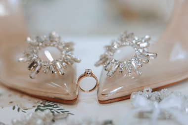 Gelinin detayları. Güzellik detaylarda gizlidir. Yüksek topuklu gelin ayakkabıları. Elmaslı altın alyans. Parfümler. Küpeler. Düğün ayrıntıları..