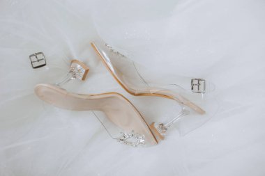 Gelinin detayları. Güzellik detaylarda gizlidir. Yüksek topuklu gelin ayakkabıları. Elmaslı altın alyans. Parfümler. Küpeler. Düğün ayrıntıları..