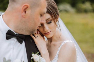 Düğün için. Aşk ve çift düğün için bahçede. Törenin ve bağlılığın kutlanması. Tarihi kaydet. Damadın, gelini ormanın arkasındaki dağlarda kucakladığına güven.