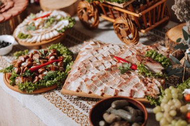 Kazak masası. Konuklar için ziyafet salonu et ziyafeti. Ev yapımı kesikler. Domuz filetosu. Lezzetli et parçaları. Et tabağı. Füme nane 'den nefis kompozisyonlar. Süzme peynir..