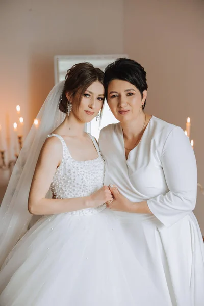 Güzel ve mutlu bir anne ve kızı, gelin, yan yana duruyorlar. Ebeveynler için en iyi gün. Düğünde hassas anlar.
