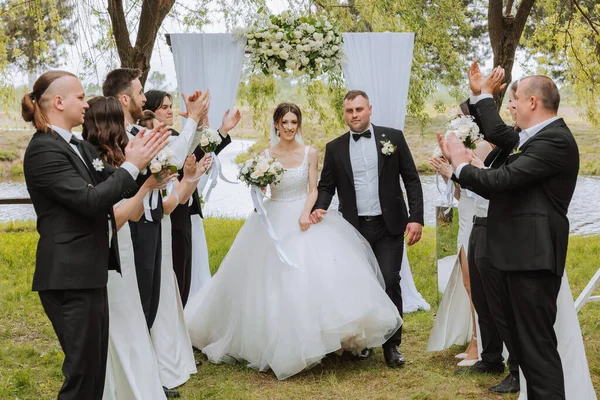 Yeni evlilerin ve düğündeki arkadaşlarının tam boy portresi. Gelin ve damat nedimelerle ve damadın arkadaşlarıyla düğünde eğleniyorlar..