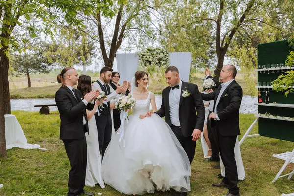 Yeni evlilerin ve düğündeki arkadaşlarının tam boy portresi. Gelin ve damat nedimelerle ve damadın arkadaşlarıyla düğünde eğleniyorlar..