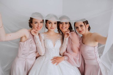Arkadaşlar sabah gelinle sevinirler. Fotoğraf çekerler, gülümserler, gelinin elbisesini bağlamasına yardım ederler..