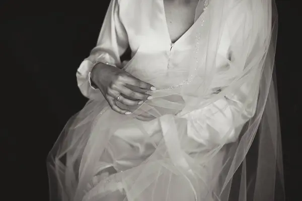 bride in white robe, close-up of hands. Wedding veil. Black and white photo. Beauty is in the details